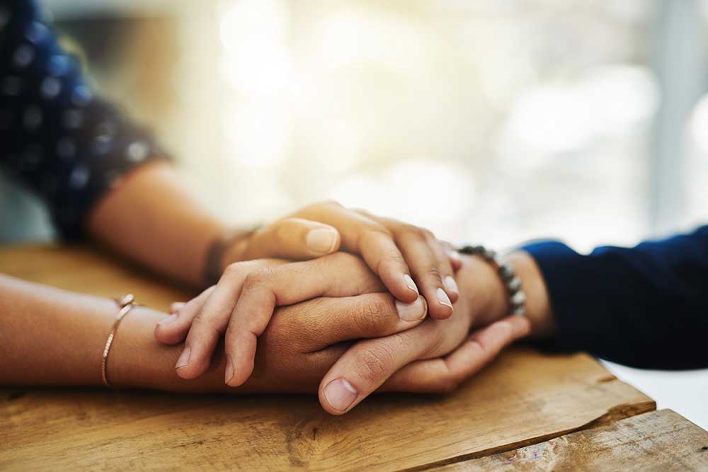 two people holding hands on a desk